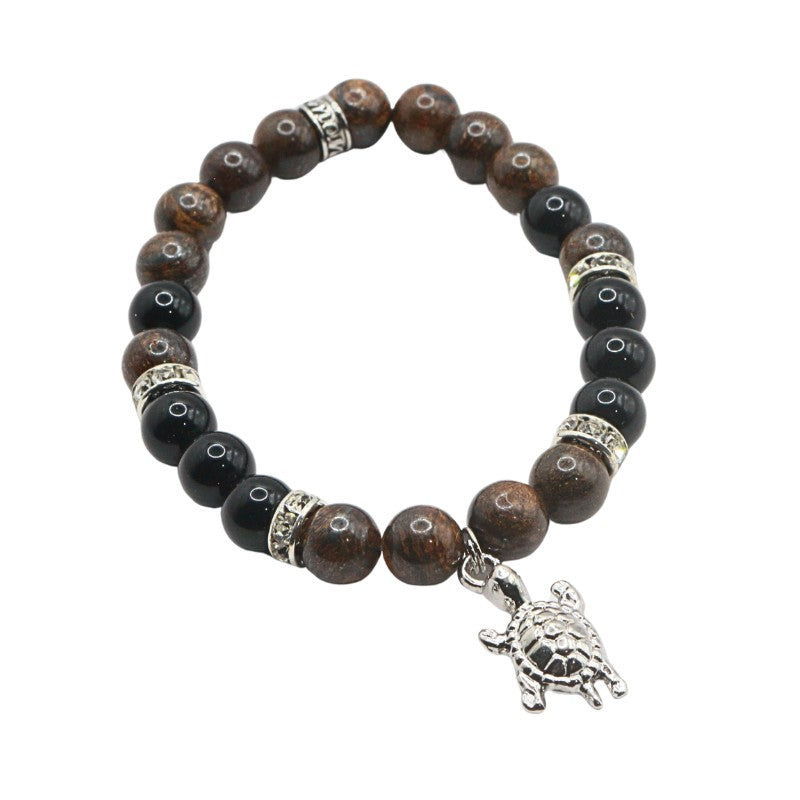 Bracelet with brown and black beads and a silver turtle charm on a white background