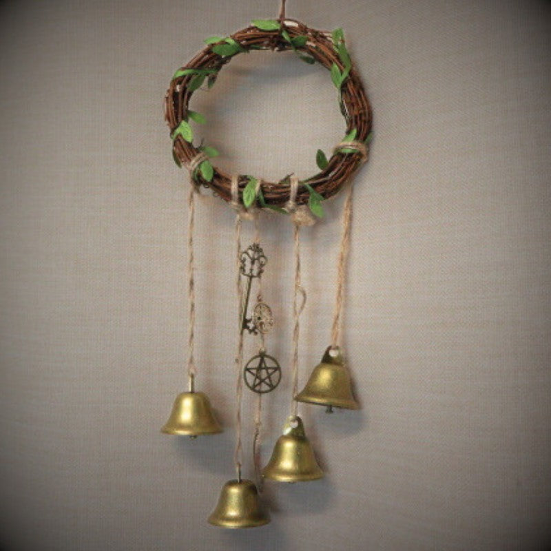twig wreath with 4 gold bells and charms hanging from it