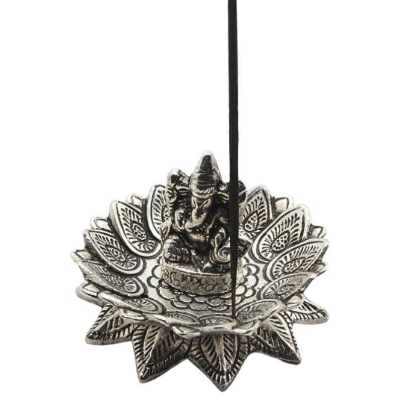 stick of incense in an aluminium incense burner of a lotus with ganesh in the centre