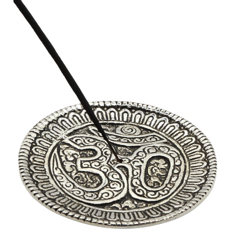 stick of incense in an aluminium incense holder with the om symbol