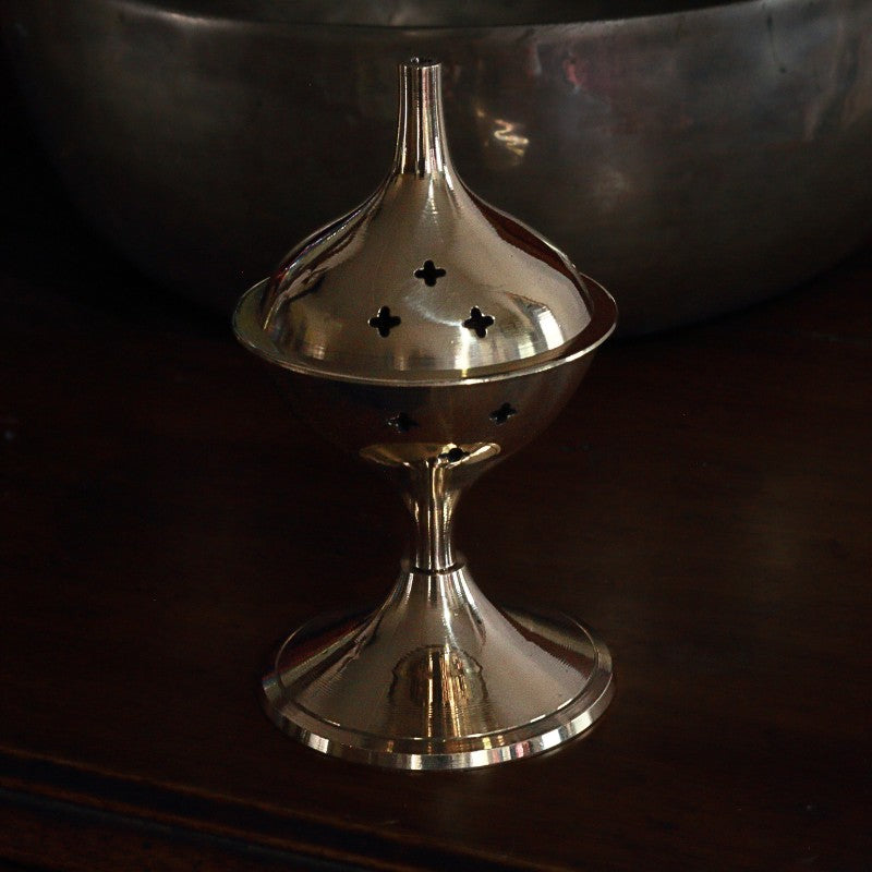 Brass incense burner on a dark background
