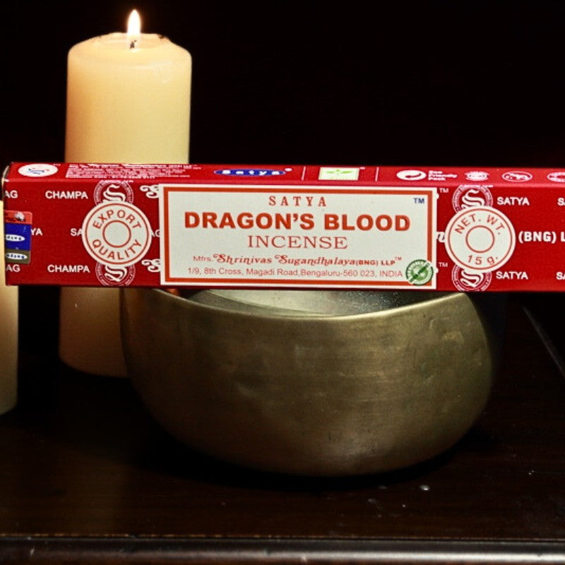 Dragon's blood incense on a brass singing bowl in front of beeswax candles