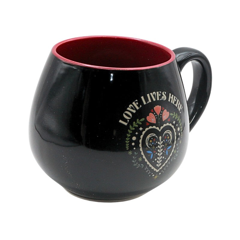Black mug with 'Love Lives Here' design on a white background