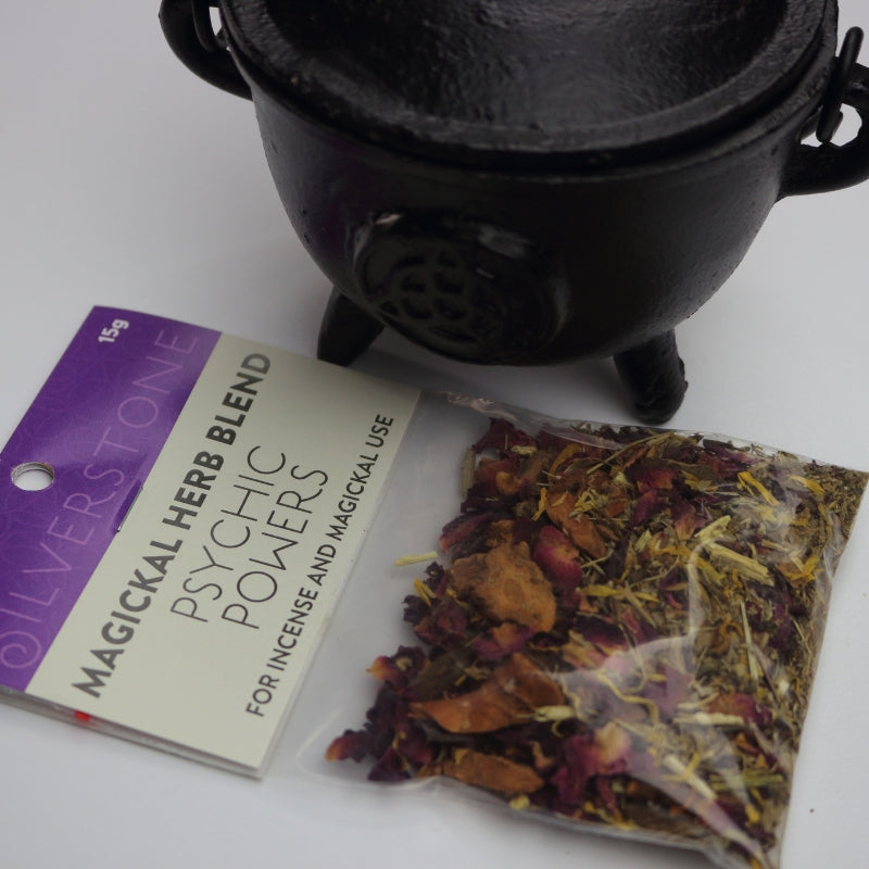 packet of magickal herbs for increasing psychic powers, in front of a black cauldron
