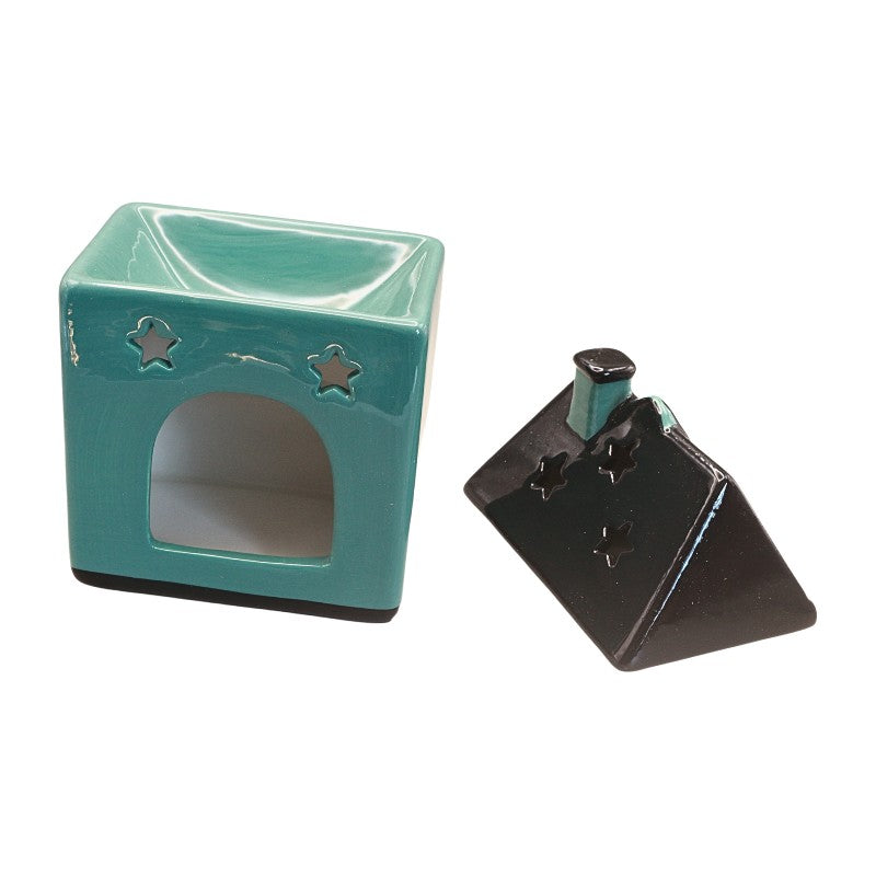 A small glossy ceramic house-shaped item in turquoise with star cutouts and a dark base, shown next to its black reverse side or lid on a plain white background.