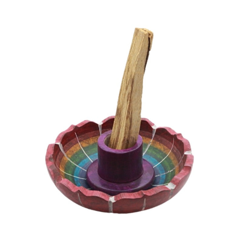 Colorful soapstone palo santo holder with a palo santo stick on a white background