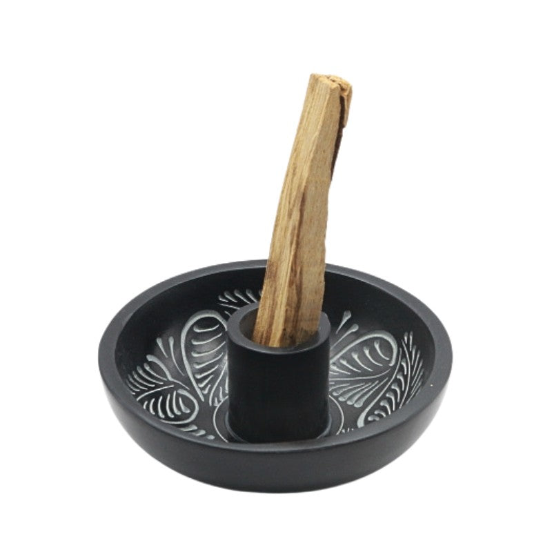 Black decorative palo santo holder with a wooden palo santo stick on a white background