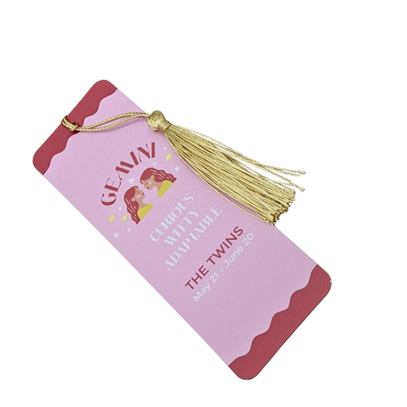 pink and red bookmark with gold tassel and white and red writing, on a white background
