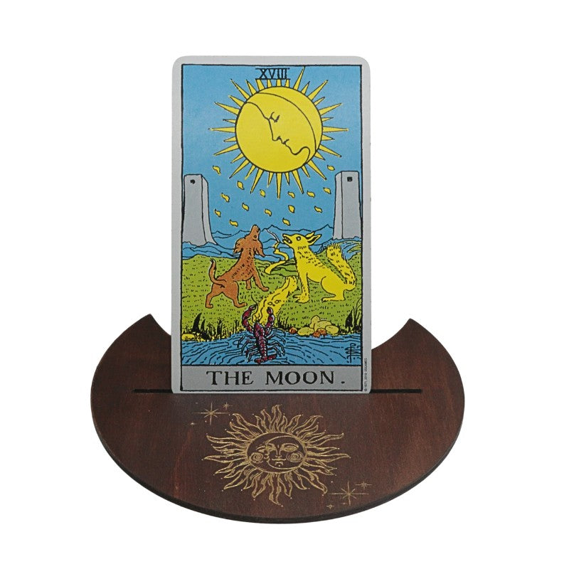 Tarot card titled 'The Moon' on a wooden stand with sun design