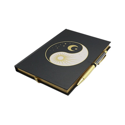 Black notebook with a yin yang design featuring a crescent moon and sun on a white background