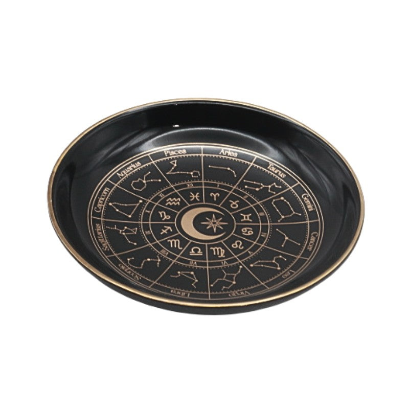 Black dish with astrological symbols on a white background