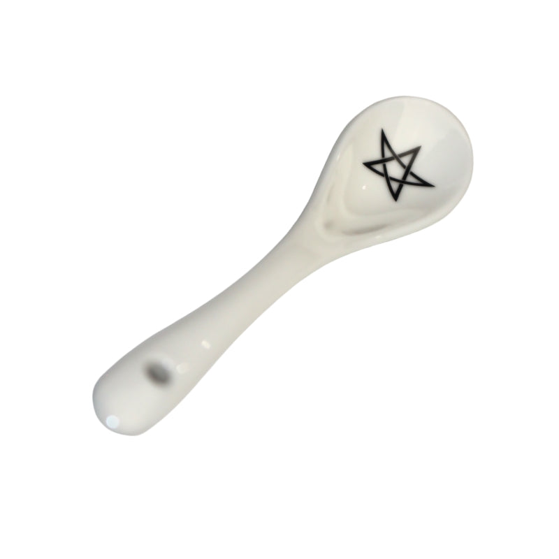 white spoon with a black pentagram drawn in the bowl of the spoon