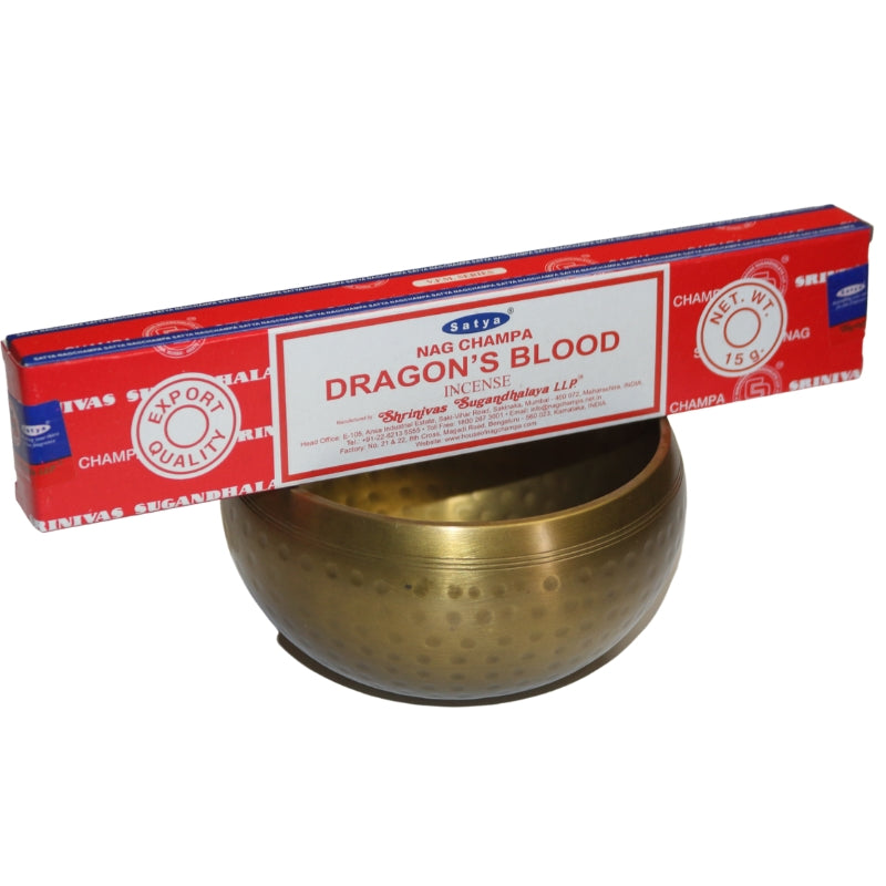 Red and white Box of Satya dragon's blood incense sitting on a brass singing bowl