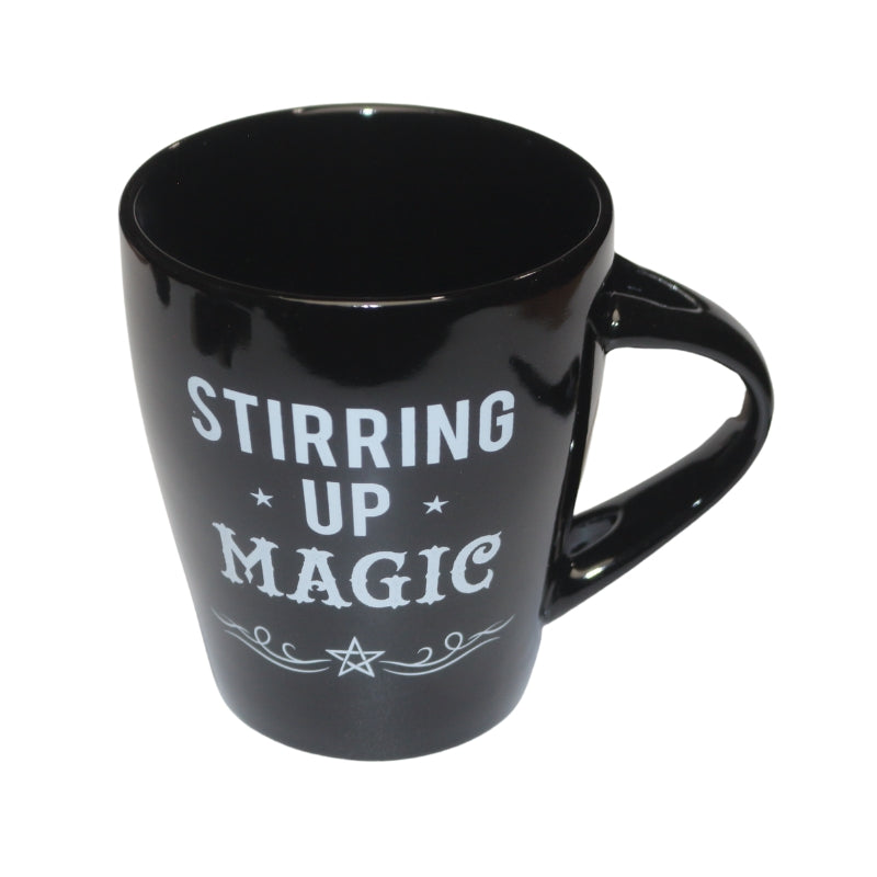 black mug decorated with the words "stirring up magic " written in white