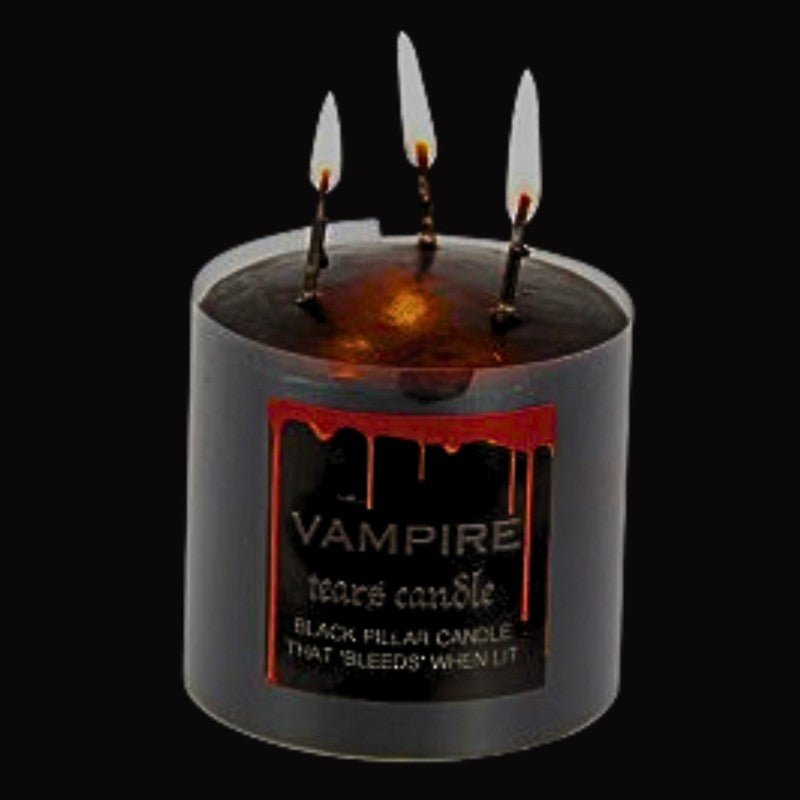 lit black pillar candle that bleeds red wax when lit