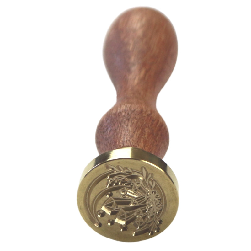Brass wax seal stamp of a crescent moon, flowers and crystals on a wooden handle