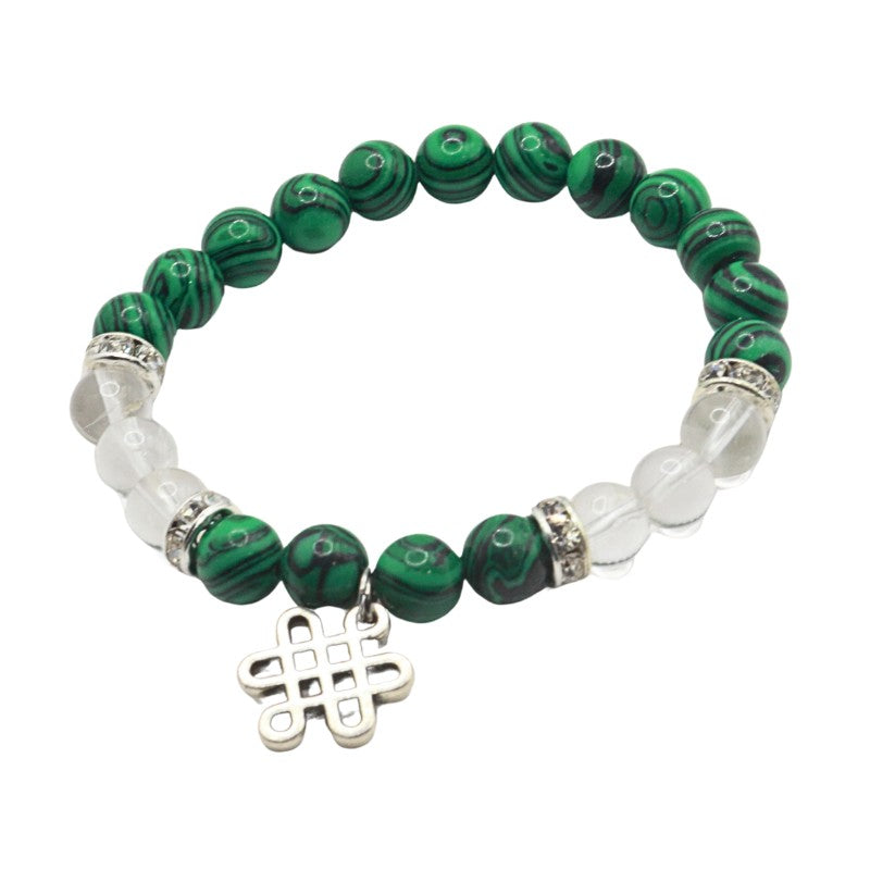 Green beaded bracelet with silver charm on a white background