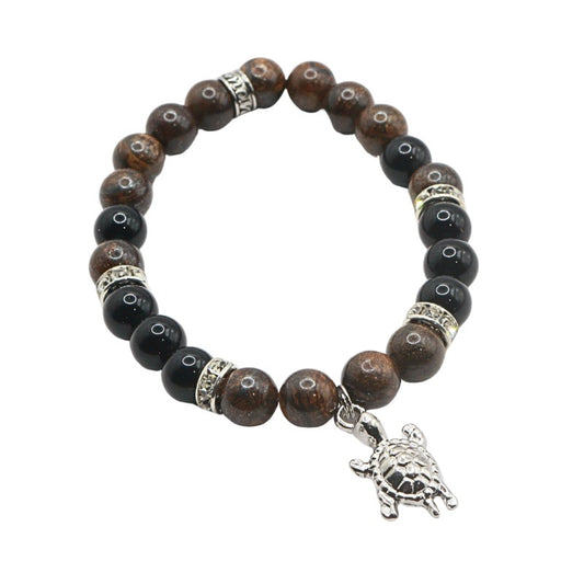 Bracelet with brown and black beads and a silver turtle charm on a white background