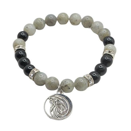 Bracelet with black, gray, and silver beads and a moon charm on a white background