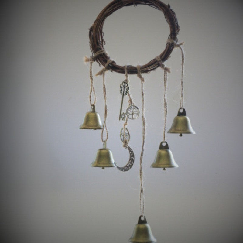 twig wreath with 5 gold bells and charms hanging from it