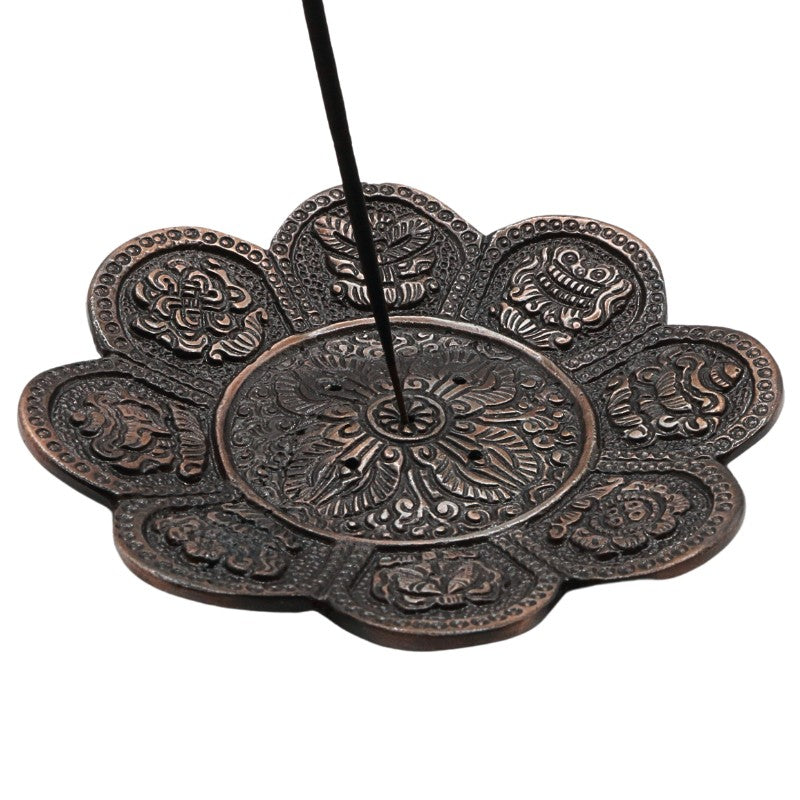 incense stick in a bronze coloured aluminium incense holder 