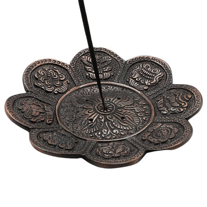 incense stick in a bronze coloured aluminium incense holder 