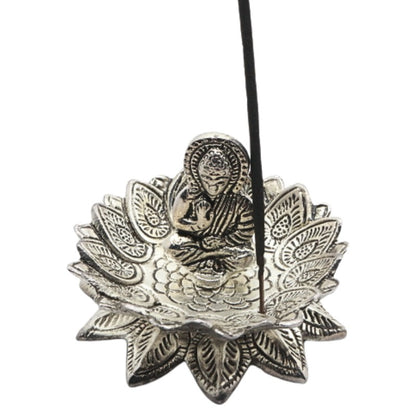 incense stick on a lotus shaped   aluminium incense burner with a buddha in the centre
