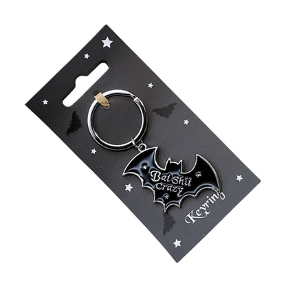 bat shaped black and silver keyring on a black backing card with illustrations of bats and stars.