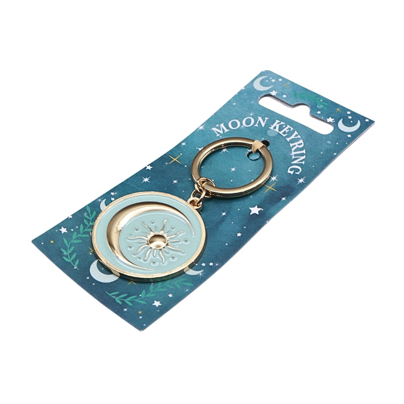 blue keyring with gold chain and gold sun and moon, on a blue card and white background