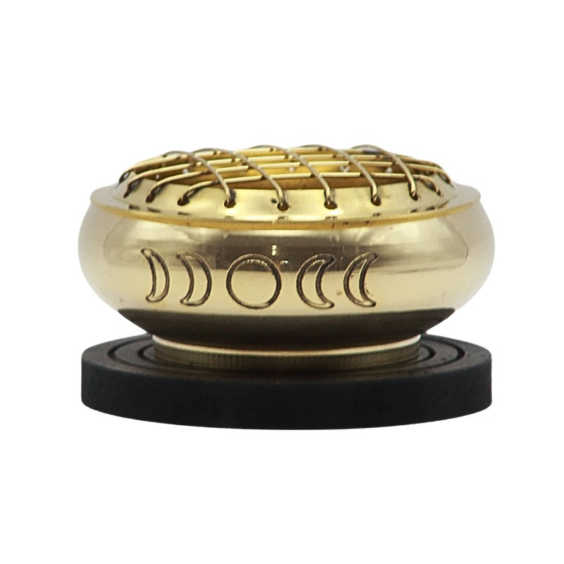 Brass charcoal incense burner engraved with the phases of the moon, sitting on a wooden base plate 