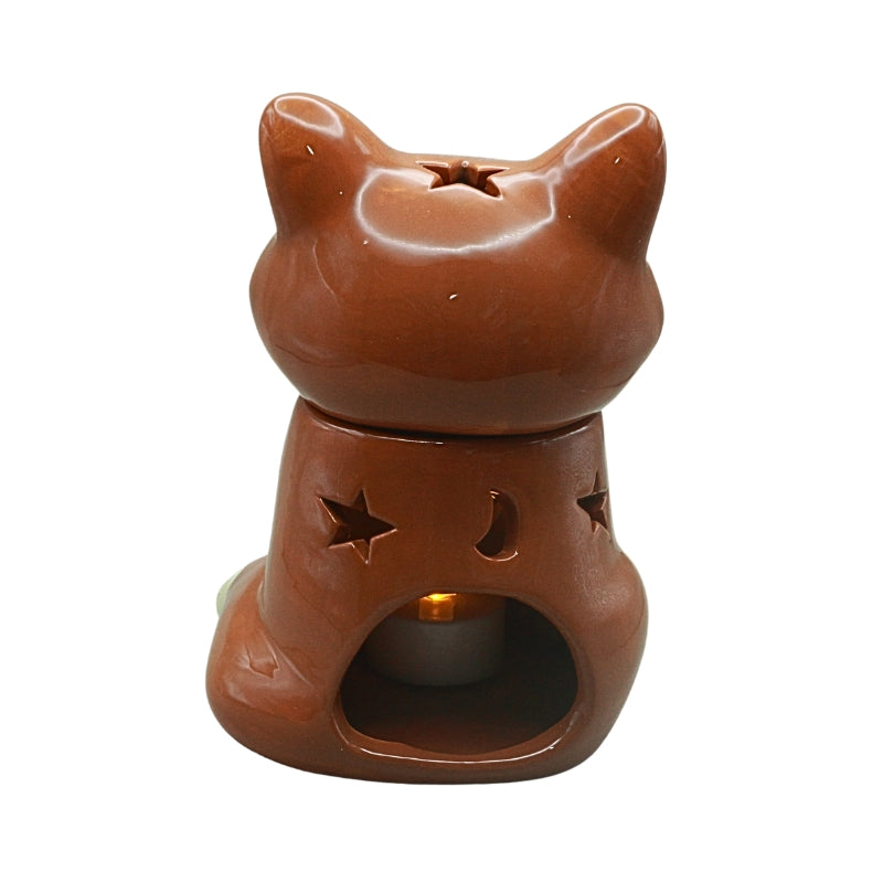 Rear view of the ceramic fox oil burner with a lit tealight inside and star and crescent moon cutouts.