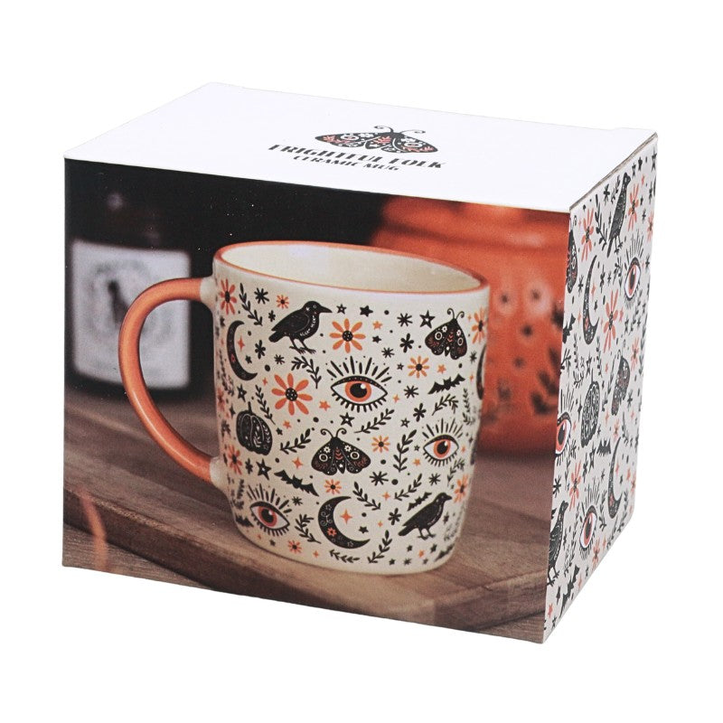 image of ceramic mug with black and orange spooky designs on a white background on packaging box