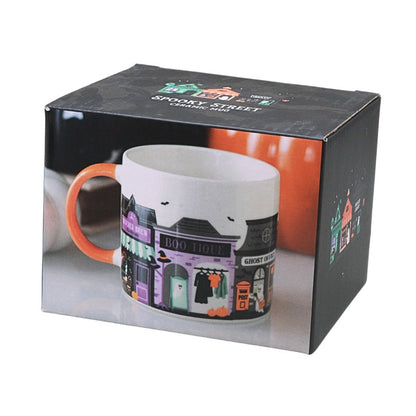 box featuring an image of a mug with spooky house designs on a white background