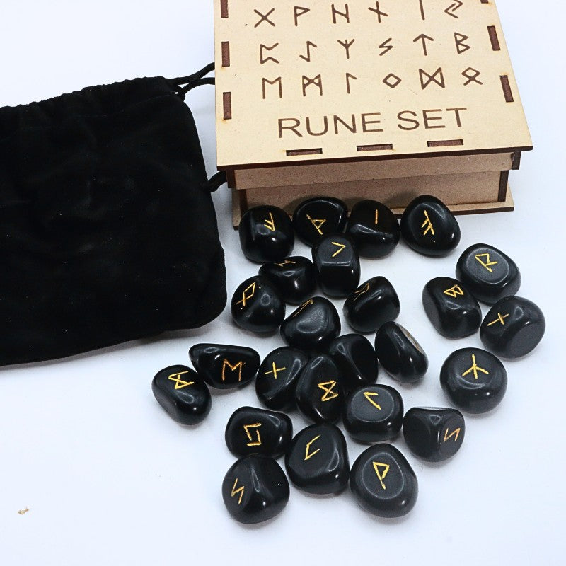 Black rune stones with yellow symbols next to a wooden box labeled 'Rune Set' on a white background.