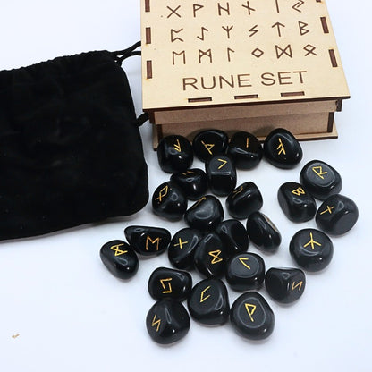 Black rune stones with yellow symbols next to a wooden box labeled 'Rune Set' on a white background.