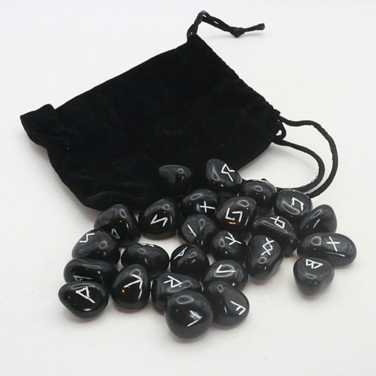 Set of black rune stones with white symbols on a white background, accompanied by a black drawstring bag.