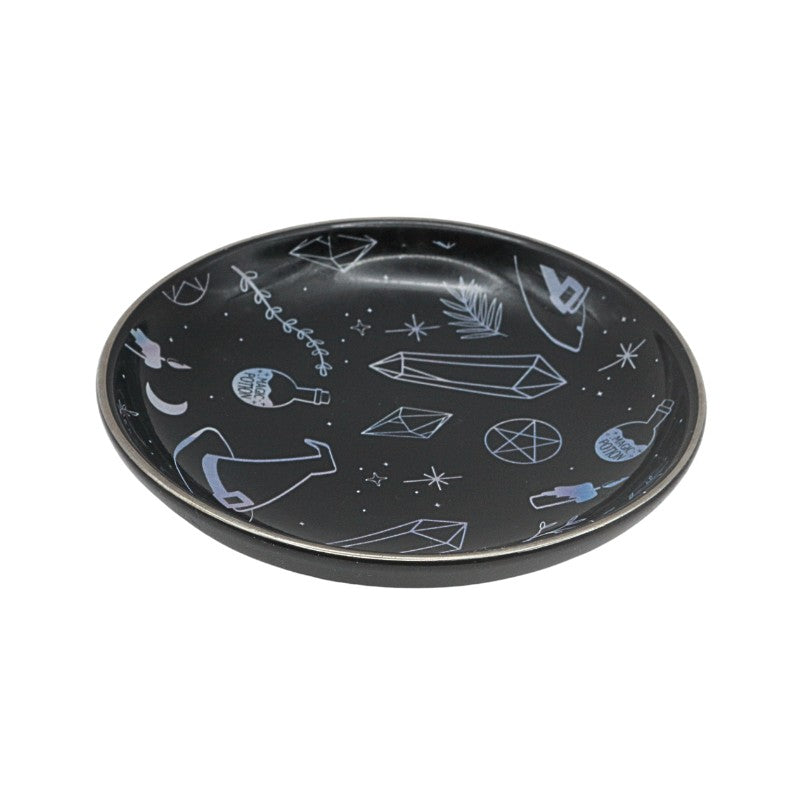 Black plate with white geometric and abstract designs on a white background