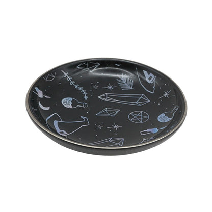 Black plate with white geometric and abstract designs on a white background