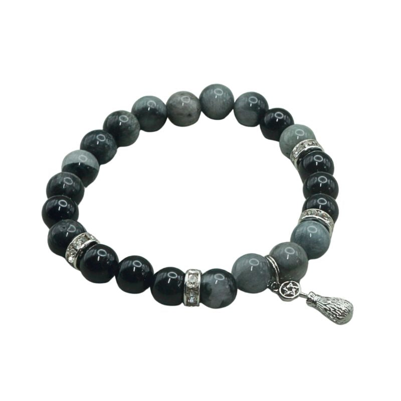 crystal bracelet with a silver coloured broom and pentacle charm, on a white background
