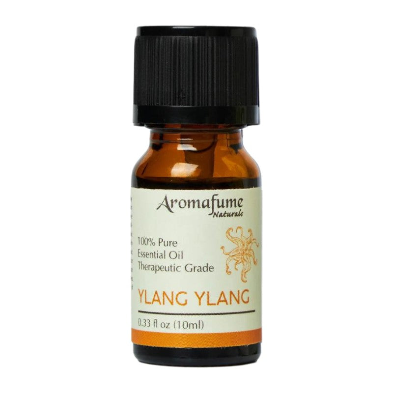 A small amber glass bottle of Aromafume Naturals Ylang Ylang essential oil with a black ribbed cap and a cream label with orange text, shown on a plain white background.