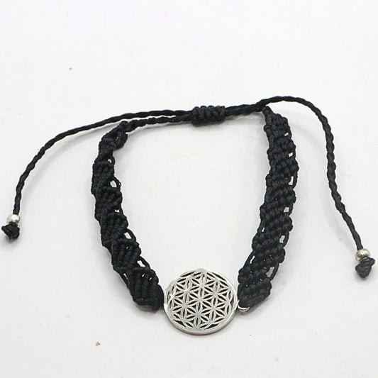 Black braided bracelet with a silver pendant on a white background