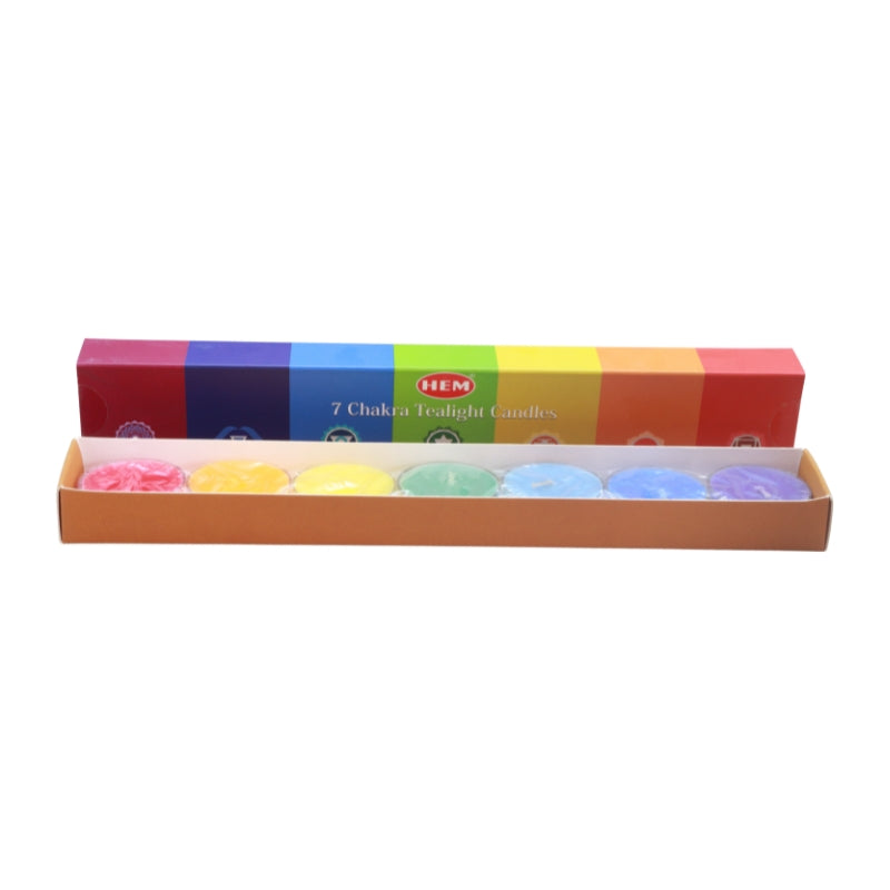 A box of HEM 7 Chakra Tealight Candles, with the lid showing a rainbow-colored design and the tray below containing seven small round candles in pink, yellow, white, green, blue, light blue, and purple.