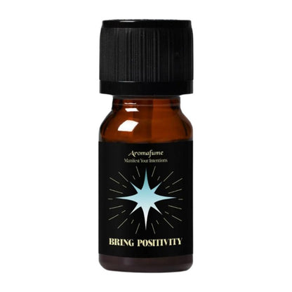 A small amber glass bottle with a black ribbed cap and a black label featuring a light blue starburst and the text 'Aromafume' and 'BRING POSITIVITY'.
