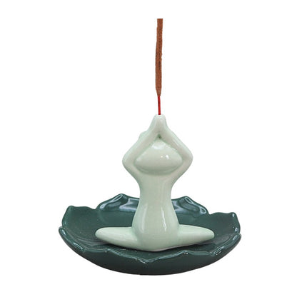green frog sitting cross legged on lily pad holding incense stick above head