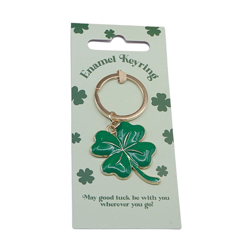 Green four-leaf clover keychain on a green card with shamrock designs