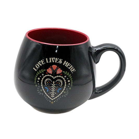 Black mug with 'Love Lives Here' design on a white background