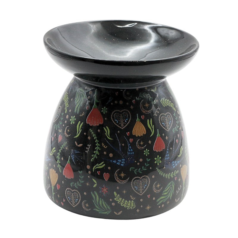 Decorative oil burner with colorful patterns on a black background