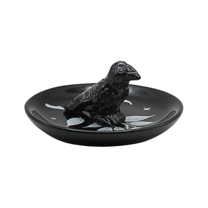 Black ceramic dish with a bird design on a white background