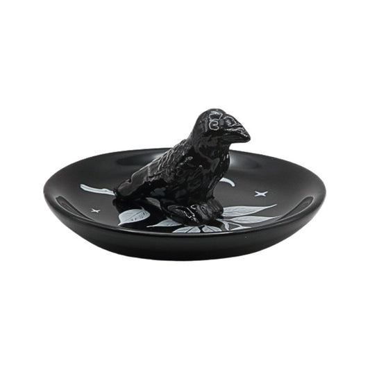 Black ceramic dish with a bird design on a white background