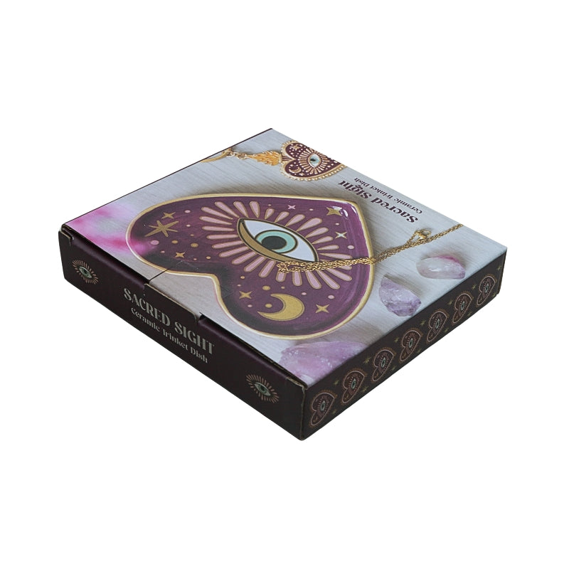 cardboard packaging box showing a purple/pink heart shaped ceramic trinket dish with an eye in the centre, on a white background